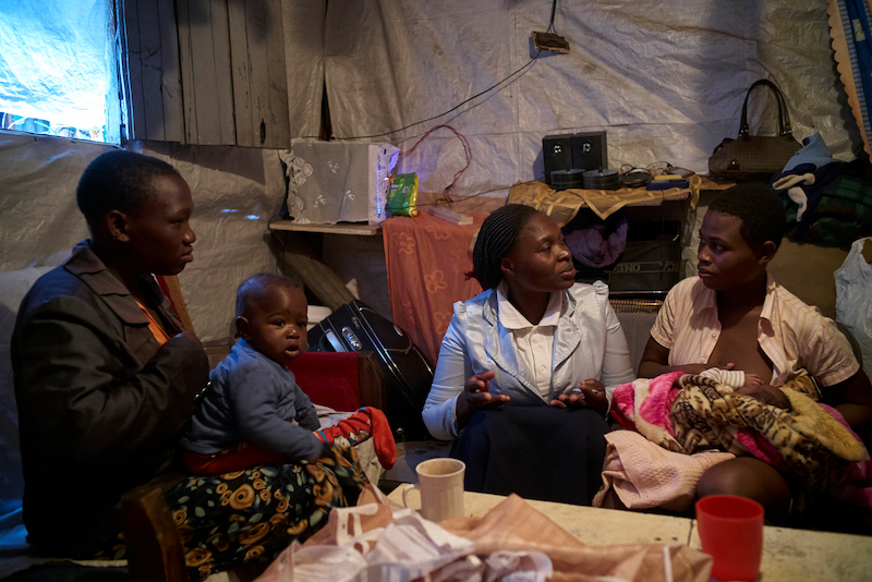 Susan Ateka (second from right), a community health worker supported by Concern, UNICEF’s implementing partner, visits Maximila, 22, (right) who gave birth to her daughter Gloria two weeks ago at her home in Mukuru, Nairobi, Kenya.