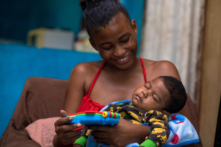 Ashley, 19, holds her 18-month-old son, Jaycean, who has cerebral palsy, at her grandmother's house in Belize City, Belize in October 2017.