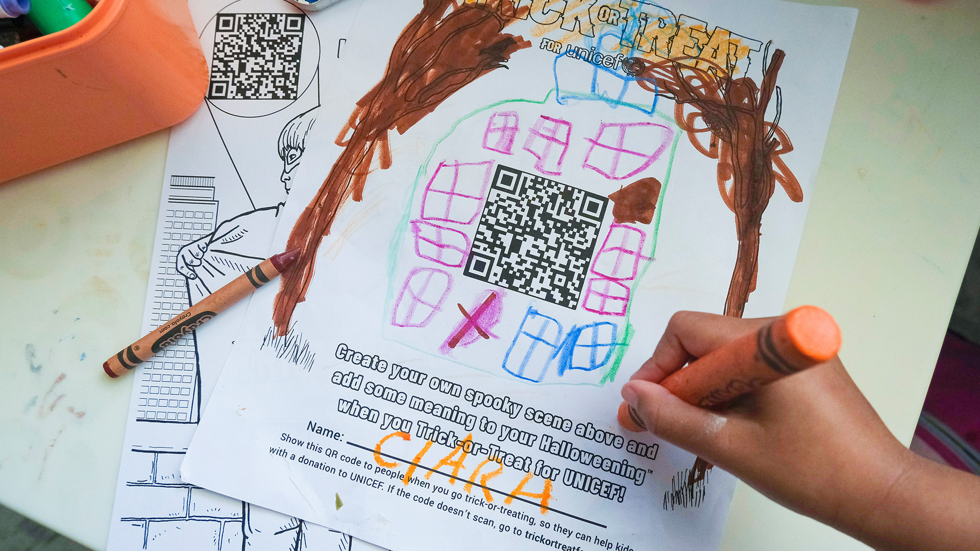 A child coloring a drawing activity page