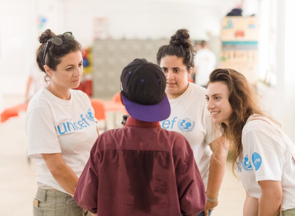 Members of UNICEF NextGen listening to an unaccompanied child migrant tell his story.