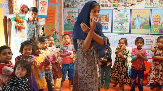Let Us Learn Bangladesh staffer leads children in a song and dance at a pre-primary education center. Credit: UNICEF Innocenti/Chavez