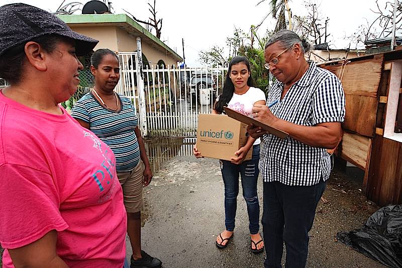 Two women deliver a UNICEF Family Dignity and Hygiene Kit to two other women in Puerto Rico to help them recover from Hurricane Maria