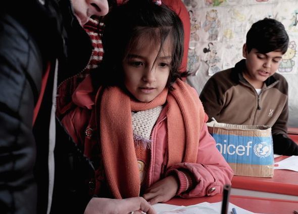 Refugee children participate in an activity, rest and warm up in a UNICEF child-friendly space at the refugee processing centre in Preševo. 