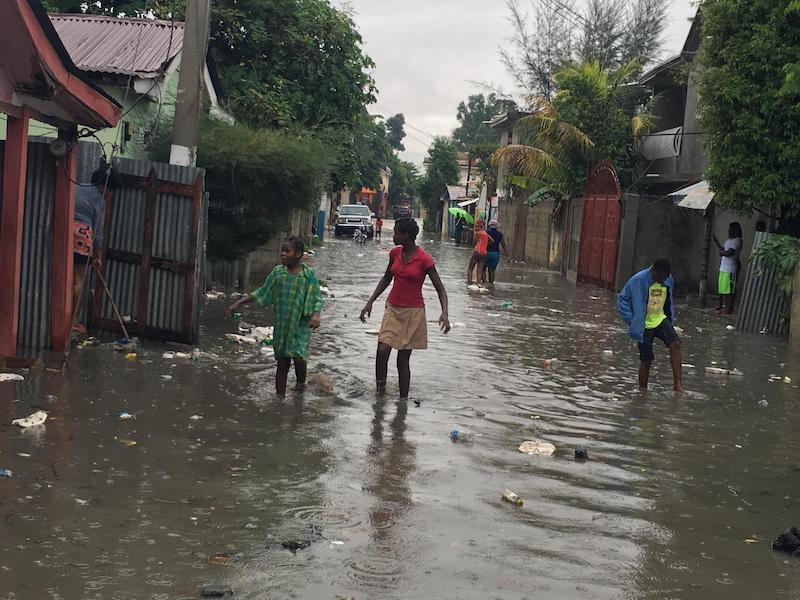 Women and children wade through a street in Hinche, Haiti as Hurricane Irma approaches, September 7, 2017.