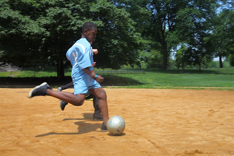 Ibrahim, with David alongside, shoots downfield during Field Day soccer.