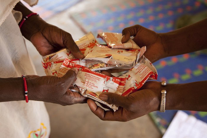 A health worker gives a supply of ready-to-use therapeutic food to the grandmother of a malnourished baby who is being discharged from a UNICEF-supported nutrition center in southern Mauritania