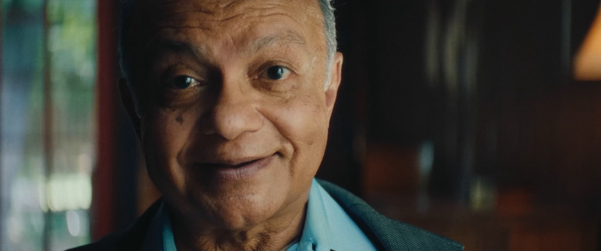 An elderly Nepalese gentleman smiles as he tells UNICEF's story