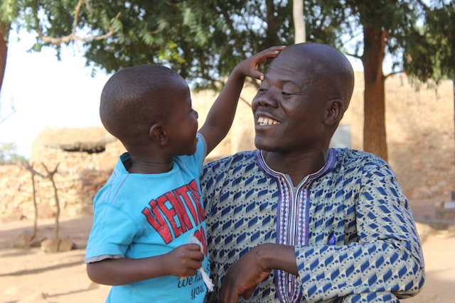 Moussa, 4, and his father, Hama, outside their home in Songho village, central Mali.