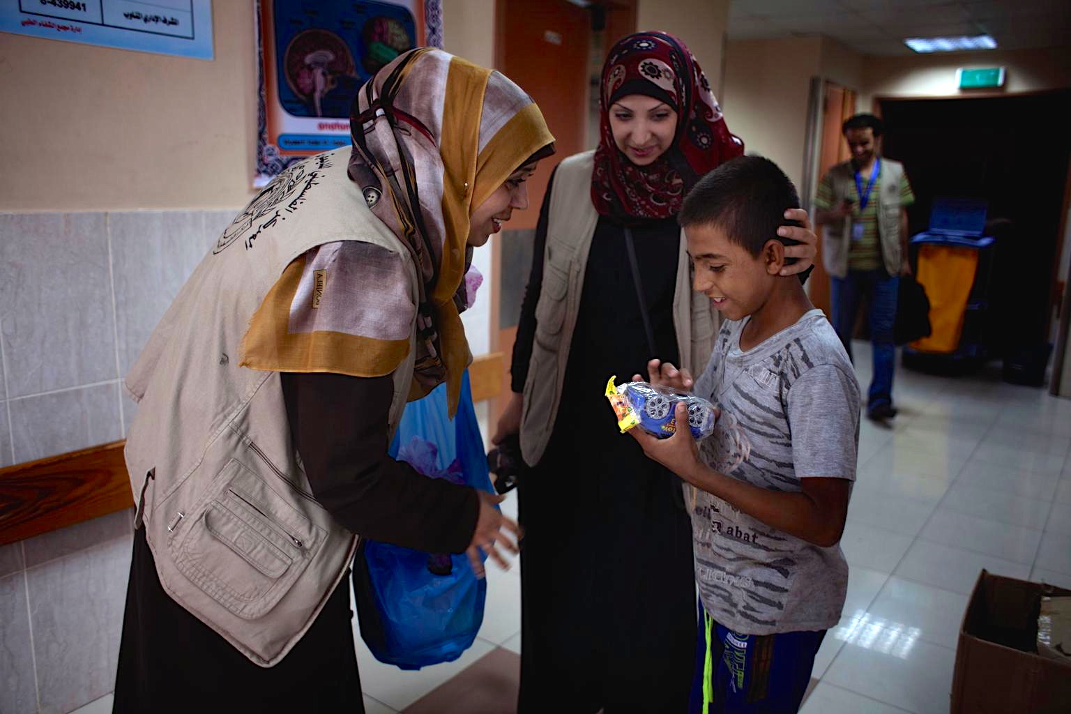 A boy receives a toy car from support workers at Al-Shifa Hospital in Gaza. © UNICEF/NYHQ2014-1039/d’Aki