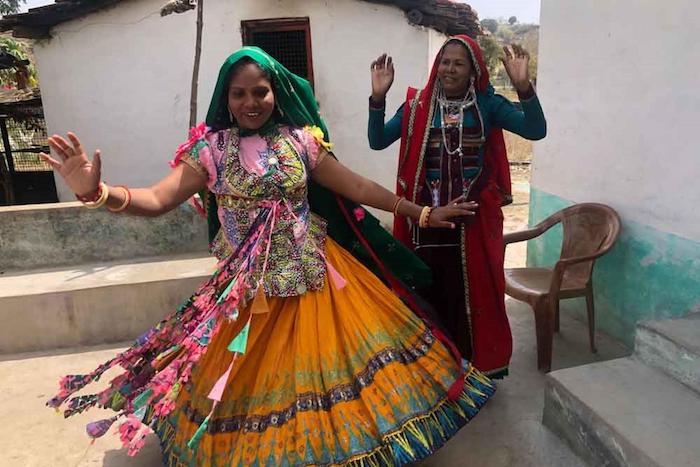 Two frontline health care workers dancing for the Garasia tribal community in India
