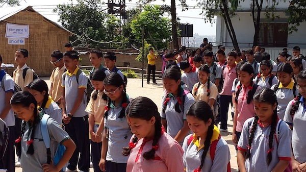 On their first day back to school, students at the Kuleshwor School in Kathmandu observe a moment of silence for Nepalis killed, injured, and missing since the earthquakes.