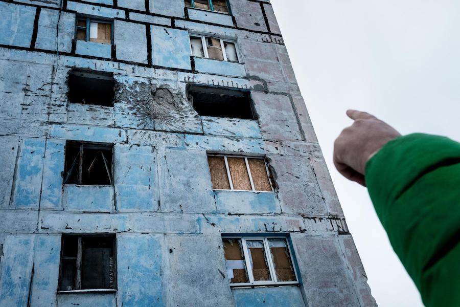 Vadim, 9, points to damage on his old home, in a building known locally as the "coloring book" in Avdiivka, Dontesk Oblast, Ukraine, November 2017. 