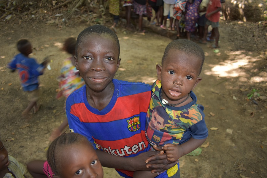 A boy carries his younger brother. Kamaworan, Bombali District, Sierra Leone. UNICEF. 
