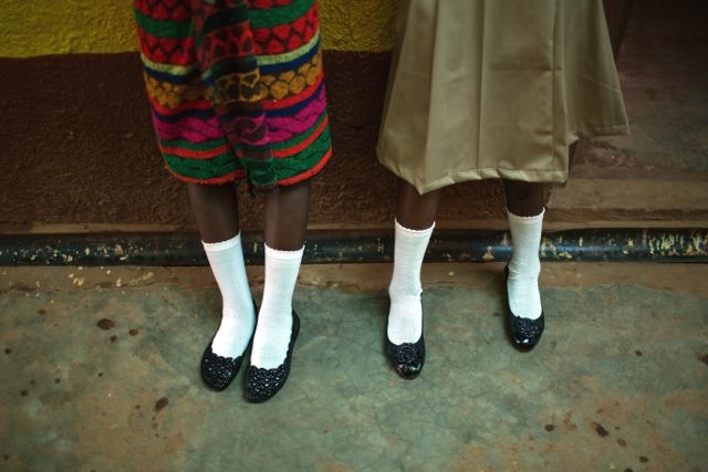 On April 14, 2015, two girls show the clothes they have donned for their first day back to school at a UNICEF-supported interim care center, for children affected by Ebola, in a suburb of Liberia’s capital, Freetown. © UNICEF Liberia/2015