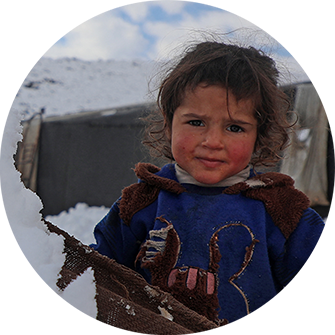 A child wears a tattered Mickey Mouse sweater outside in the snow