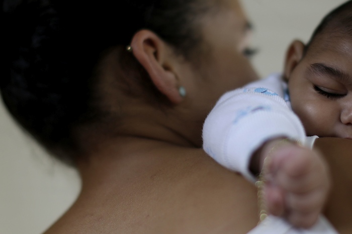 Alice,15 years old, holds her a 4-month old baby born with microcephaly in Recife. 