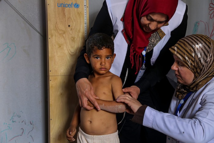 Hayder, 5, from Salah al-Din, is measured by health workers in Al-Takya Al-Kasnazaniya Camp for displaced Iraqis in Baghdad