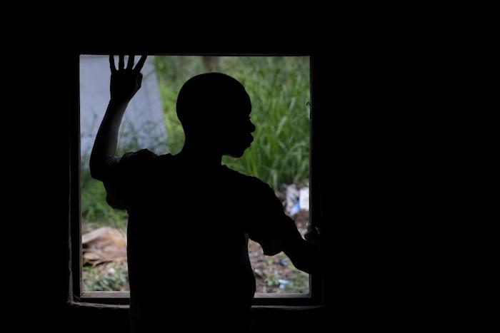 A boy who was abducted by an armed group in South Sudan looks out of a window of a UNICEF-supported childcare center after being released.