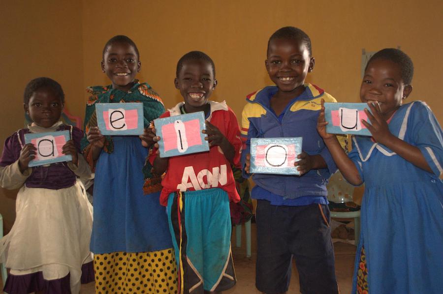 Young children learn their vowels at Tigwirizane Early Childhood Development Center, supported by UNICEF, in Mangochi, Malawi in 2018.