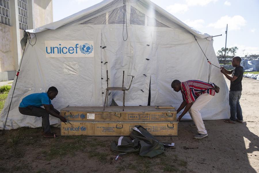 men set up a UNICEF distribution tent at the Samora Michel High School in Beira. This tent will be used to distribute needed supplies to people that has been displaced by the floods caused by Cyclone Idai.