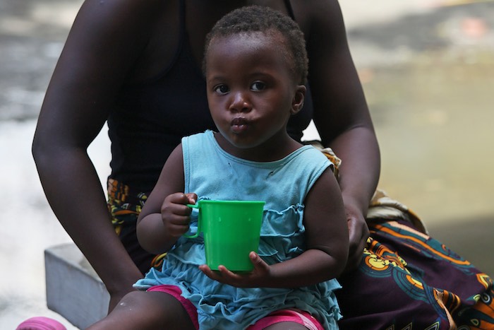 On 22 March 2019 in Beira in Mozambique, a woman sits with her child as UNICEF Executive Director Henrietta H. Fore visits a secondary school used to shelter evacuees from Cyclone Idai. UNICEF support includes health supplies and tents.