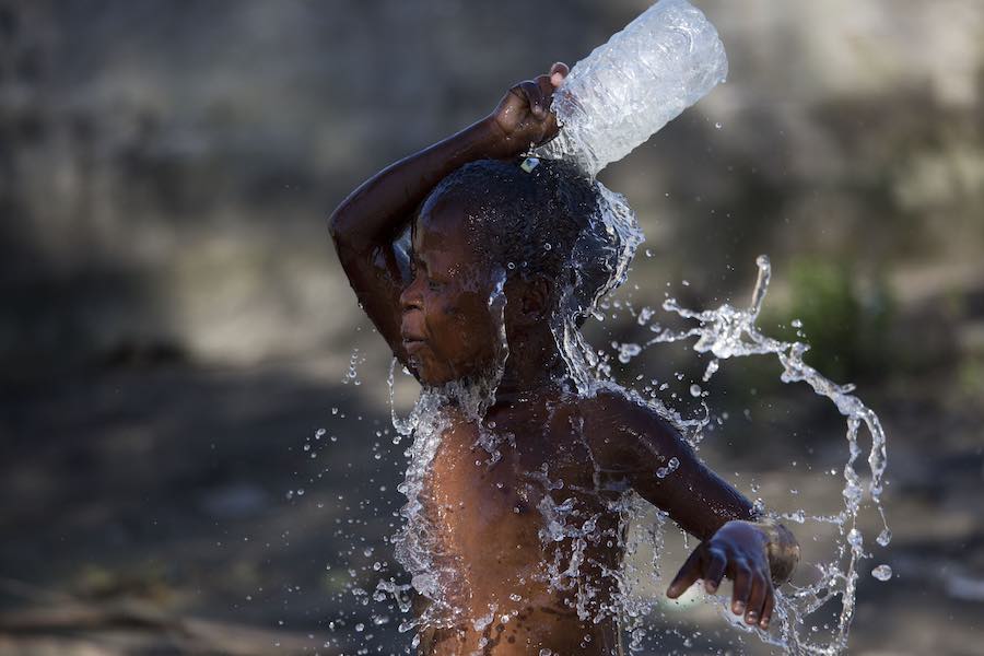 On 24 March 2019 in Mozambique, a child washes himself with dirty water in an area that was flooded after Cyclone Idai made landfall in Beira.