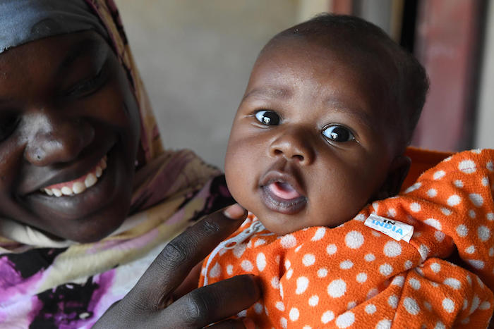 A mother and child wait to be vaccinated by UNICEF and partners in Chad in February 2016.