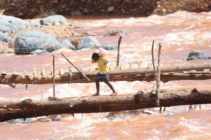 A young boy crosses a bridge near a spot where houses were swept away when Cyclone Idai hit Coppa in Risitu Valley Chimanimani in this Wednesday, April, 10, 2019 photo.The two boys both lost their parents when the cyclone struck the valley. Gore still rem