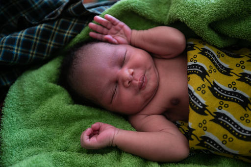 A newborn baby in Uganda sleeps peacefully, wrapped in a clean warm blanket provided to mothers just after delivery. The Newborn Kit contains all the essential items every mom needs, including blankets, diapers, baby clothes, vaccines and vitamin supplements for mom.