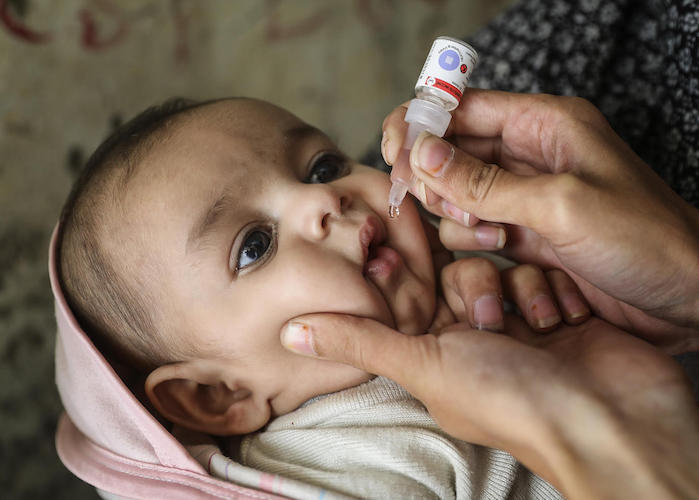 A UNICEF-supported health worker vaccinates 3-month-old Sajjad Ali against polio in Karachi, Sindh province, Pakistan on December 13, 2018.