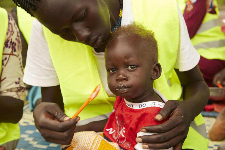 Wel Wel, 13 months, is fed porridge by his mother, Skechers Piol, at a UNICEF-supported mother-to-mother support group in Aweil, South Sudan, on September 5, 2019.
