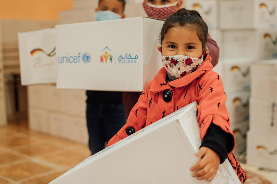 In Mafraq, Jordan, 4-year-old Lara has just received her warm winter clothing kit from UNICEF.