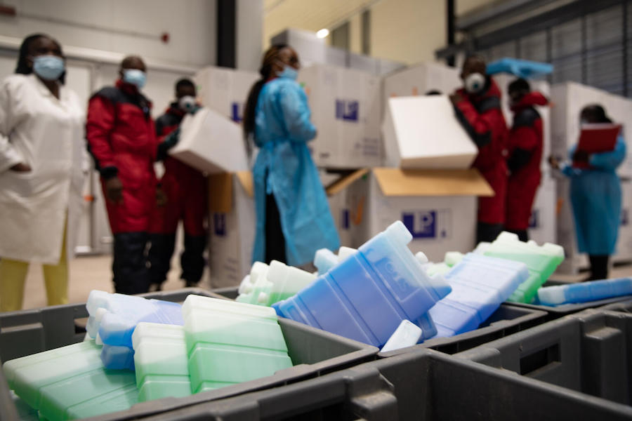 In March 2021, cold chain staff unpack COVID-19 vaccines for storage in the cold room of the vaccine storage warehouse, Kinkole commune, Kinshasa, Democratic Republic of the Congo. 