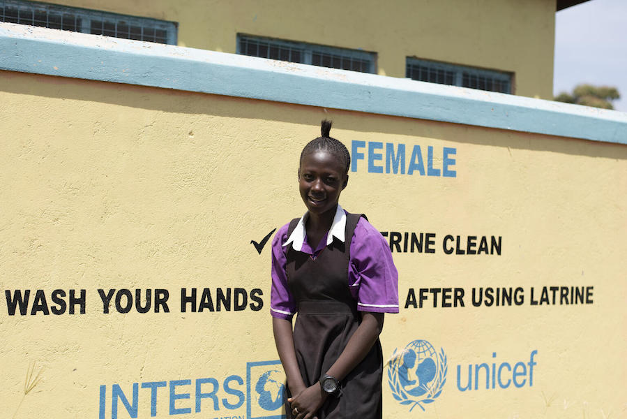 Jasmin Blessing (16) is standing outside a newly constructed latrine block at Torit West Primary School in South Sudan, February 2021.