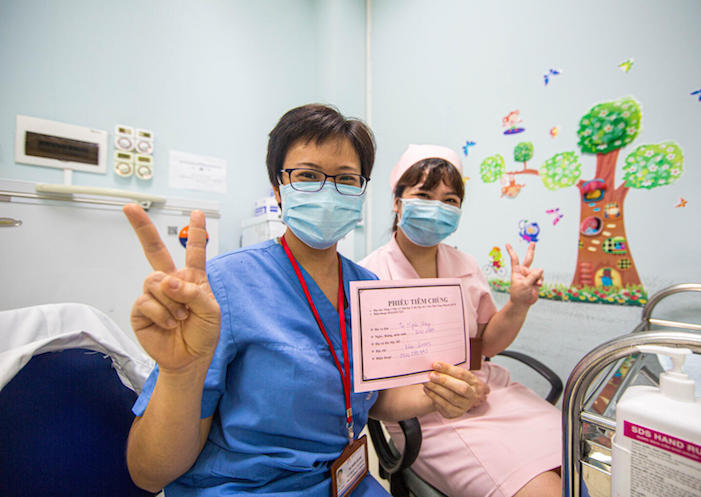 On April 26, 2021, health workers at Hanoi Medical University flash the V for vaccinated sign after receiving their COVID-19 doses supplied through the COVAX Facility. 