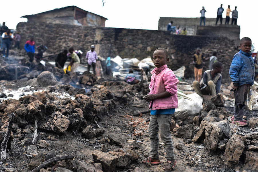 Children stand amidst lava from the volcanic eruption of Mount Nyiragongo, which occurred late on May 22, 2021 in eastern Democratic Republic of Congo.