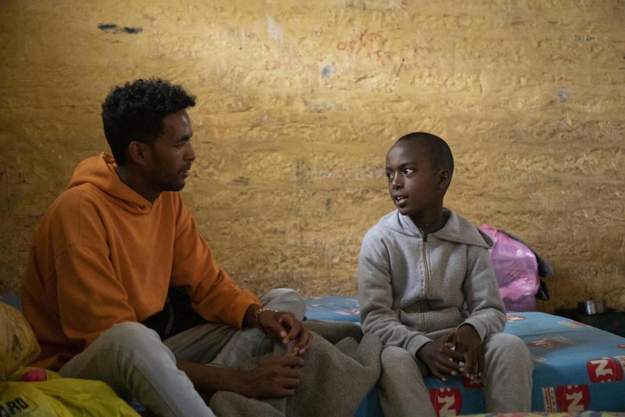 Displaced from his home by conflict in northern Ethiopia, 11-year-old Temesgen, right, is living with his family in an emergency shelter in a school in Mekelle in 2021.