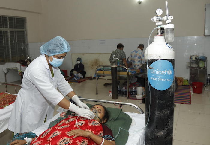 A health worker provides a patient with oxygen supplied by UNICEF at a hospital in Barishal, Bangladesh