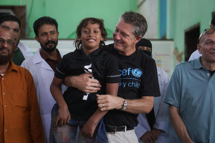 Emad, 11, who was severely injured in an explosion, is held by UNICEF spokesperson James Elder at a UNICEF-supported prosthetic center in Aden, Yemen, on Oct. 14, 2021.