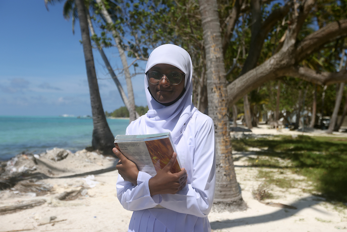 Fathimath Maoona binth Anis, 15, at the beach right in front of their school in Dhiffushi, Maldives. The beach has suffered from severe erosion following sea level rise and Dhiffushi school is now only within 100ft of the sea, leading to regular flooding 