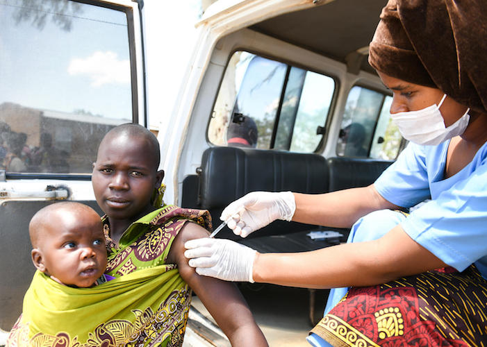 Naomi Phiri, 19, holds her baby daughter, Madalitso, as she gets her first dose of COVID-19 vaccine in Chiwinga village, central Malawi on December 14, 2021. 
