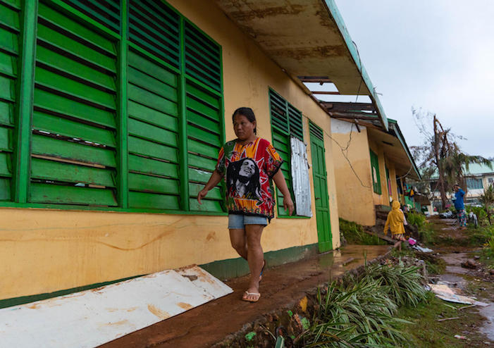 Nelly Cariño walks to the classroom where most members of her family have evacuated. More than a week after Typhoon Odette wreaked havoc on Dinagat Island, the family still can’t go home. They don’t have enough resources to rebuild what they have lost.