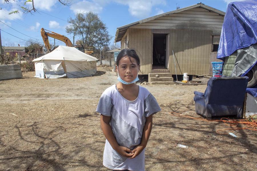 Ma'ata, 10, stands in front of her home in Kanokupolu village on Tongatapu, Tonga’s main island, showing the damage caused by the Hunga Tonga-Hunga Ha’apai underwater volcano eruption and tsunami in January 2022.