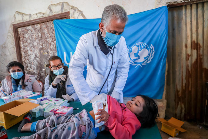Doctor who is part of a UNICEF-supported mobile health team examines a child at a shelter for displaced families in Hasakah, northeast Syria, Jan 28, 2022.