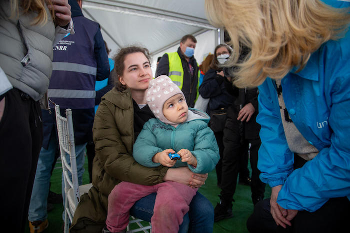 Karina and her 3-year-old daughter Luna speak with UNICEF Executive Director Catherine Russell at a UNICEF Blue Dot center in Romania.