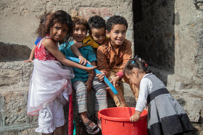 Children fill a pail with safe water in the Al Nusayria neighborhood, Al Mudhaffar district of Taizz governorate, Yemen.