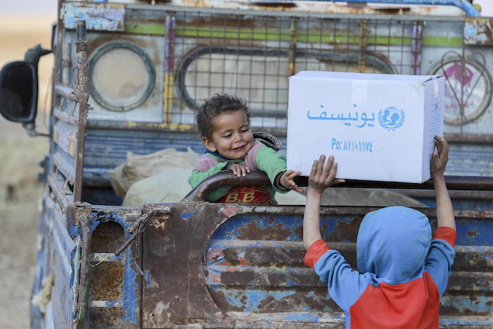 Children displaced by conflict in Syria receive a shipment of winter clothes from UNICEF in February 2022.