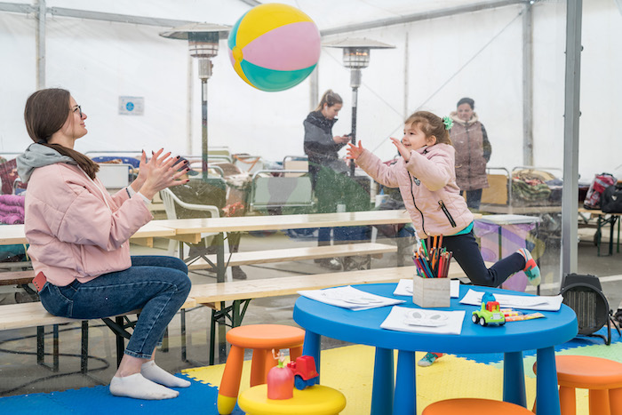 Liza, 4, of Ukraine throws a beach ball to her mother, Yulia, inside a tent at the UNICEF-UNHCR Blue Dot refugee support center in Isaccea, Romania.