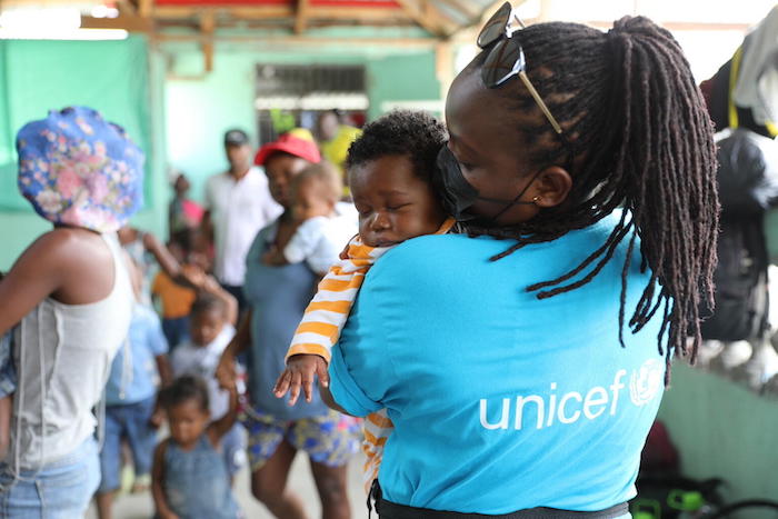 A baby is held by a UNICEF staffer at a site for children and families displaced by gang violence in Croix-des-Missions outside Port-au-Prince.