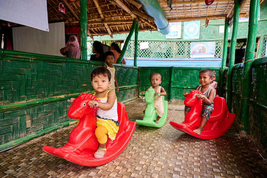 Young children play in the waiting area of a UNICEF-supported integrated nutrition facility, a dedicated space for children to play in Rohingya refugee Camp-15, Jamtoli, Cox's Bazar, Bangladesh.